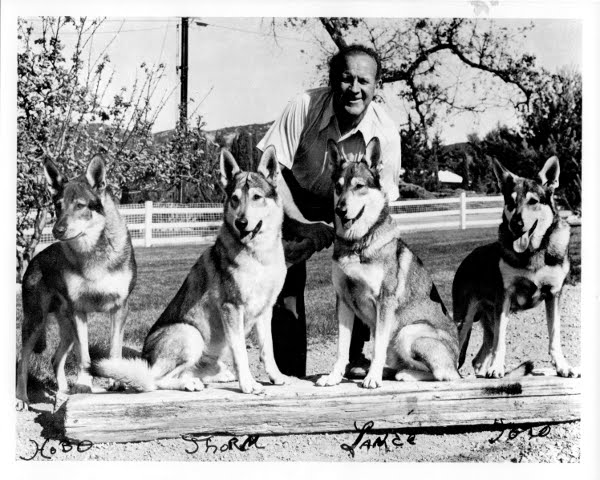 Chuck Eisenmann behind four seated German Shepherds, with handwritten dog names beneath the photograph.